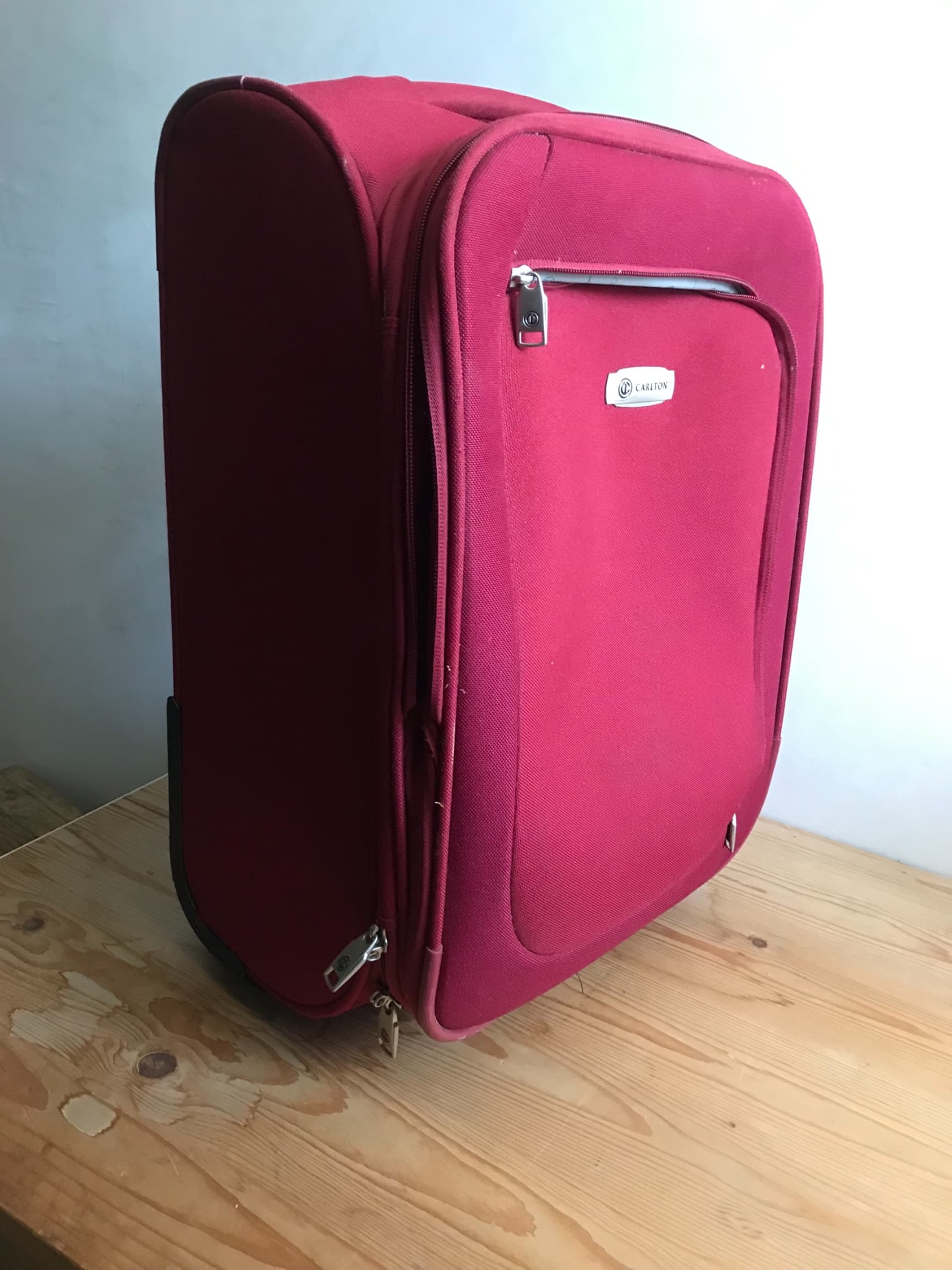 Trolley geschikt voor in het vliegtuig . Rood canvasachtige stof . Met verschillende vakken met ritsen. Twee wieltjes en uittrek handvat